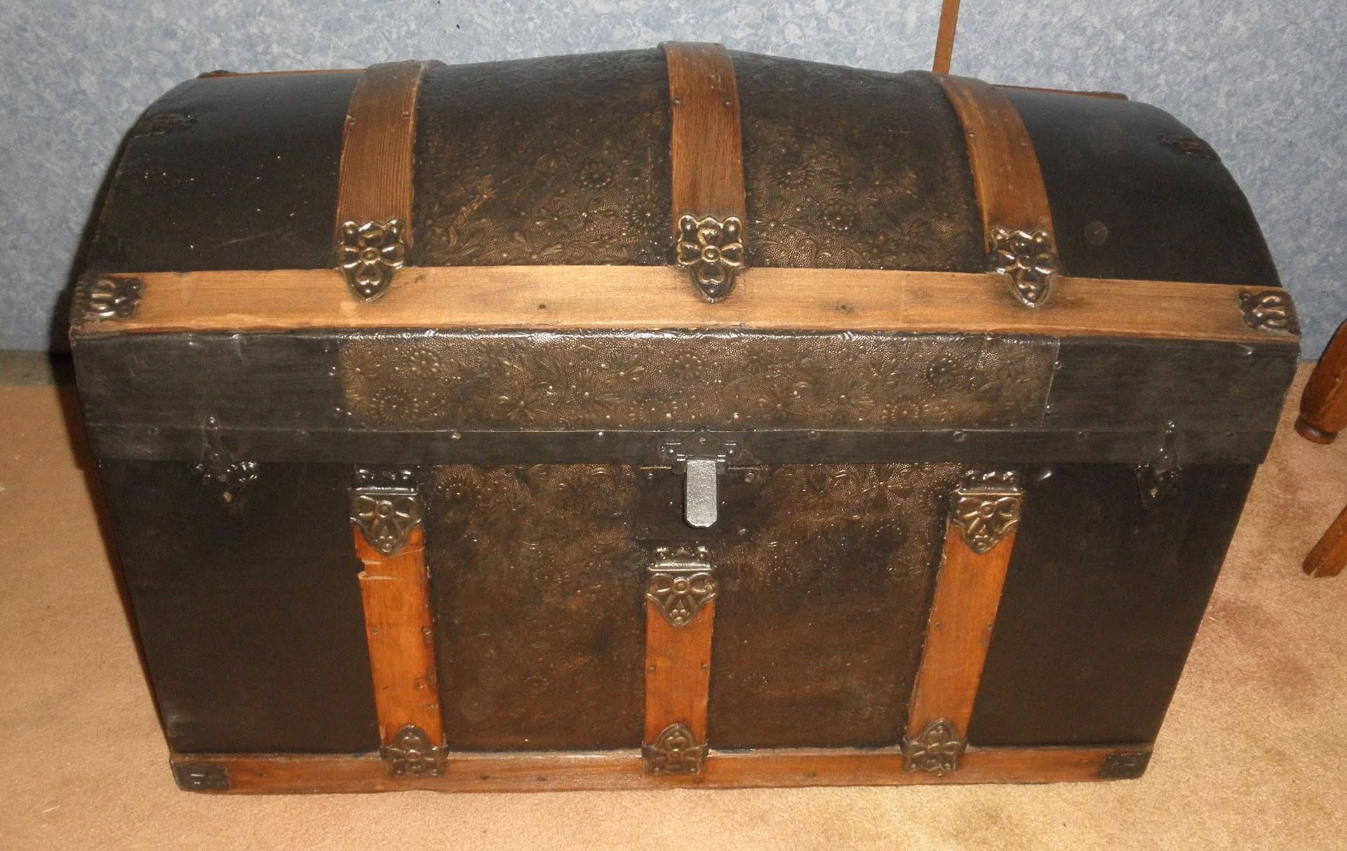 Dark wooden treasure chest with metal bands on a beige carpet