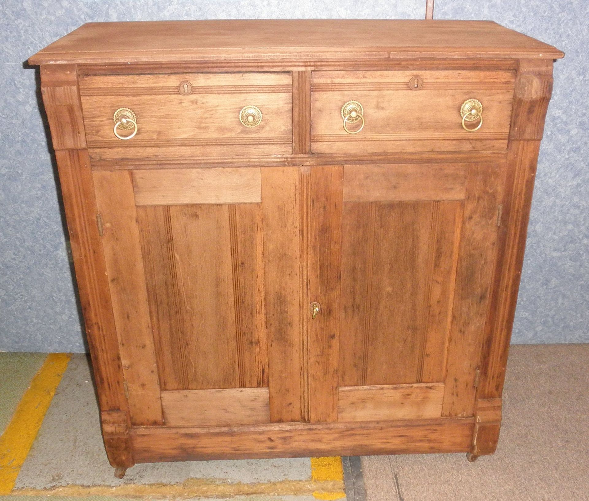 Rustic wooden cabinet with two drawers and paneled doors, front view.