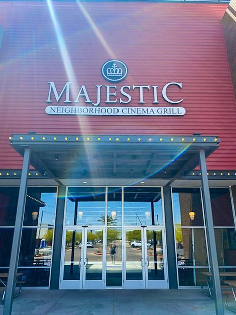 Majestic Neighborhood Cinema Grill: red building with glass doors, silver letters, and a blue logo.