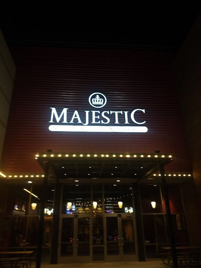Majestic restaurant entrance at night. Red facade, white sign with crown logo, string lights over the door.