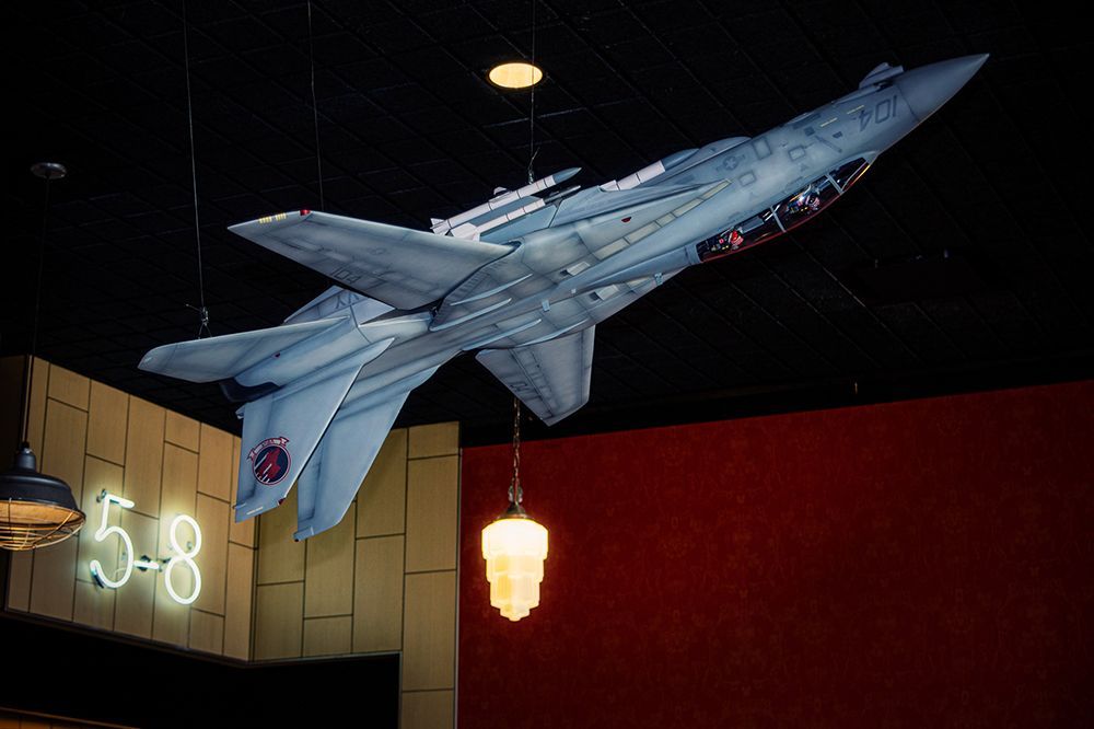 Model aircraft of a fighter jet suspended from the ceiling. A neon sign with
