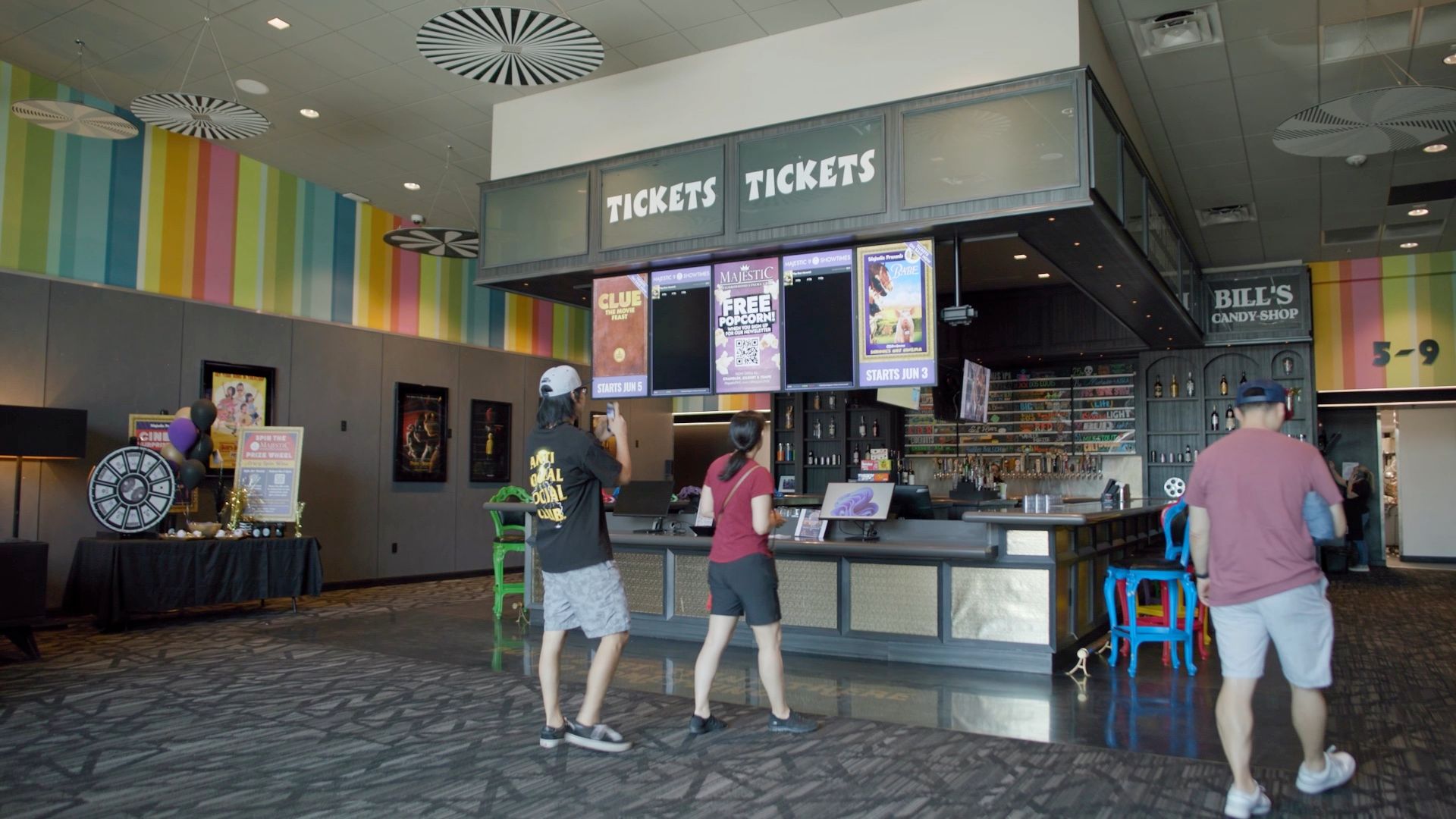 Movie theater lobby: People at ticket counter under