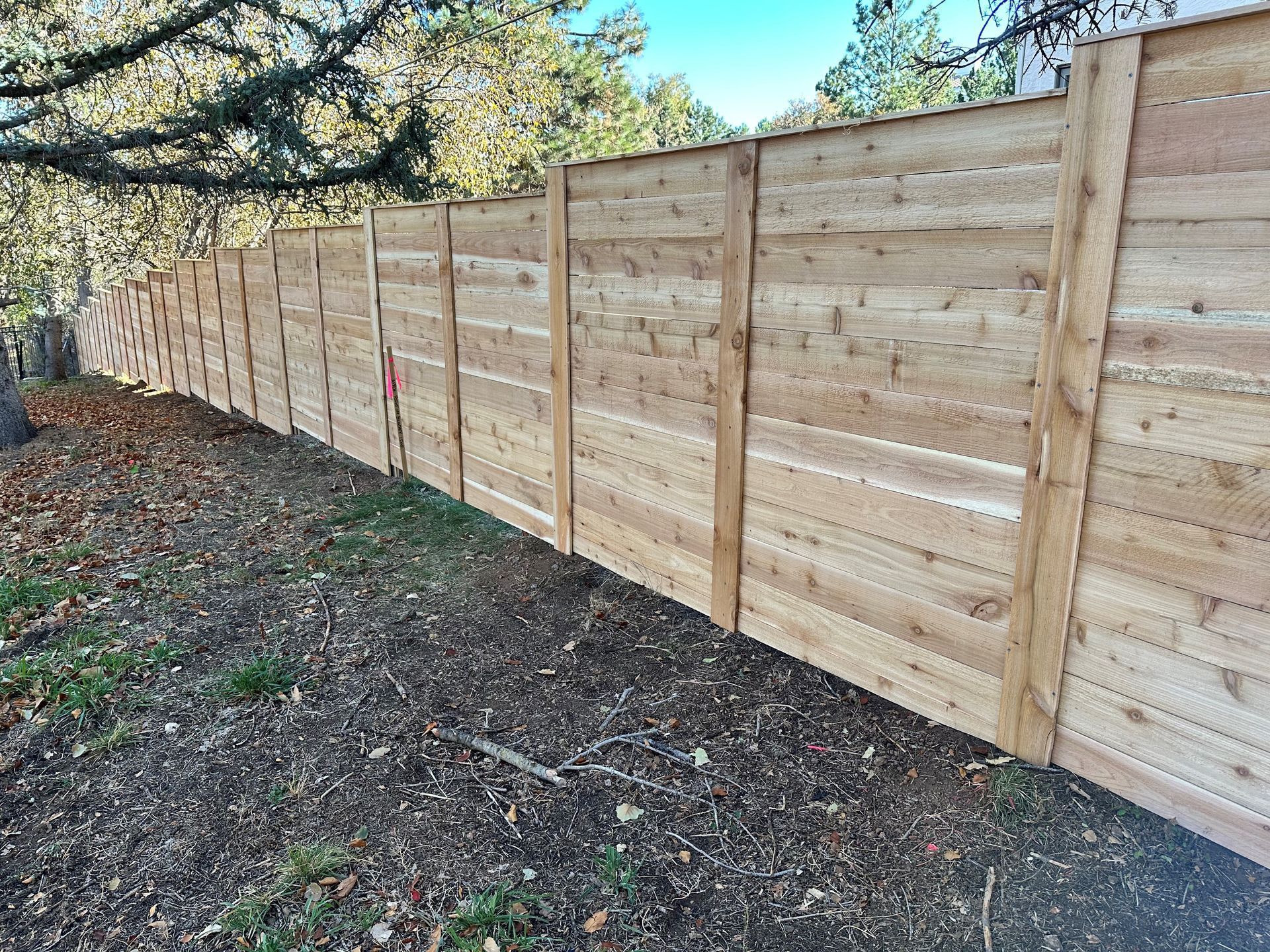A wooden fence is sitting on top of a dirt field.