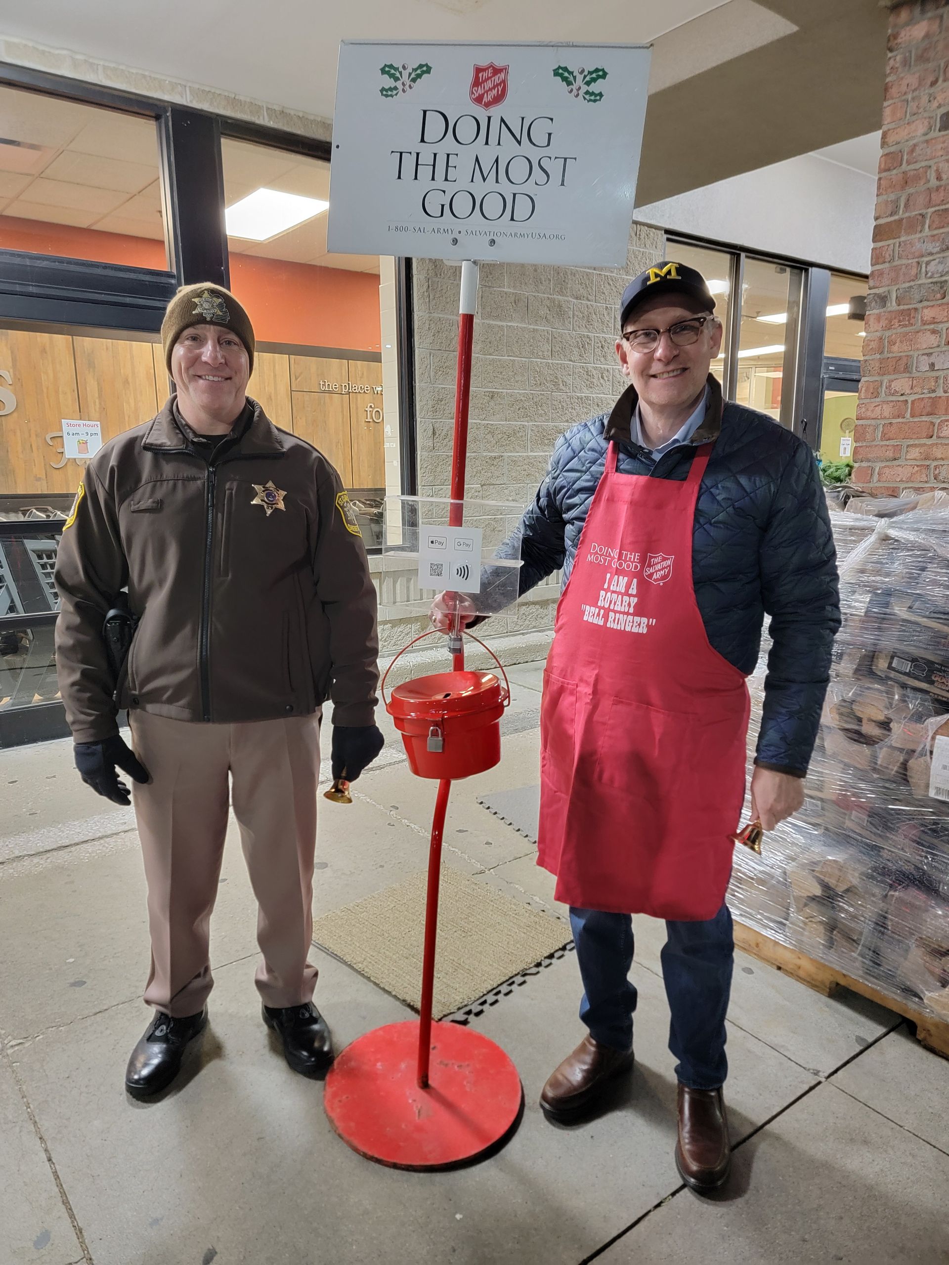 Two men are standing next to each other on a sidewalk.