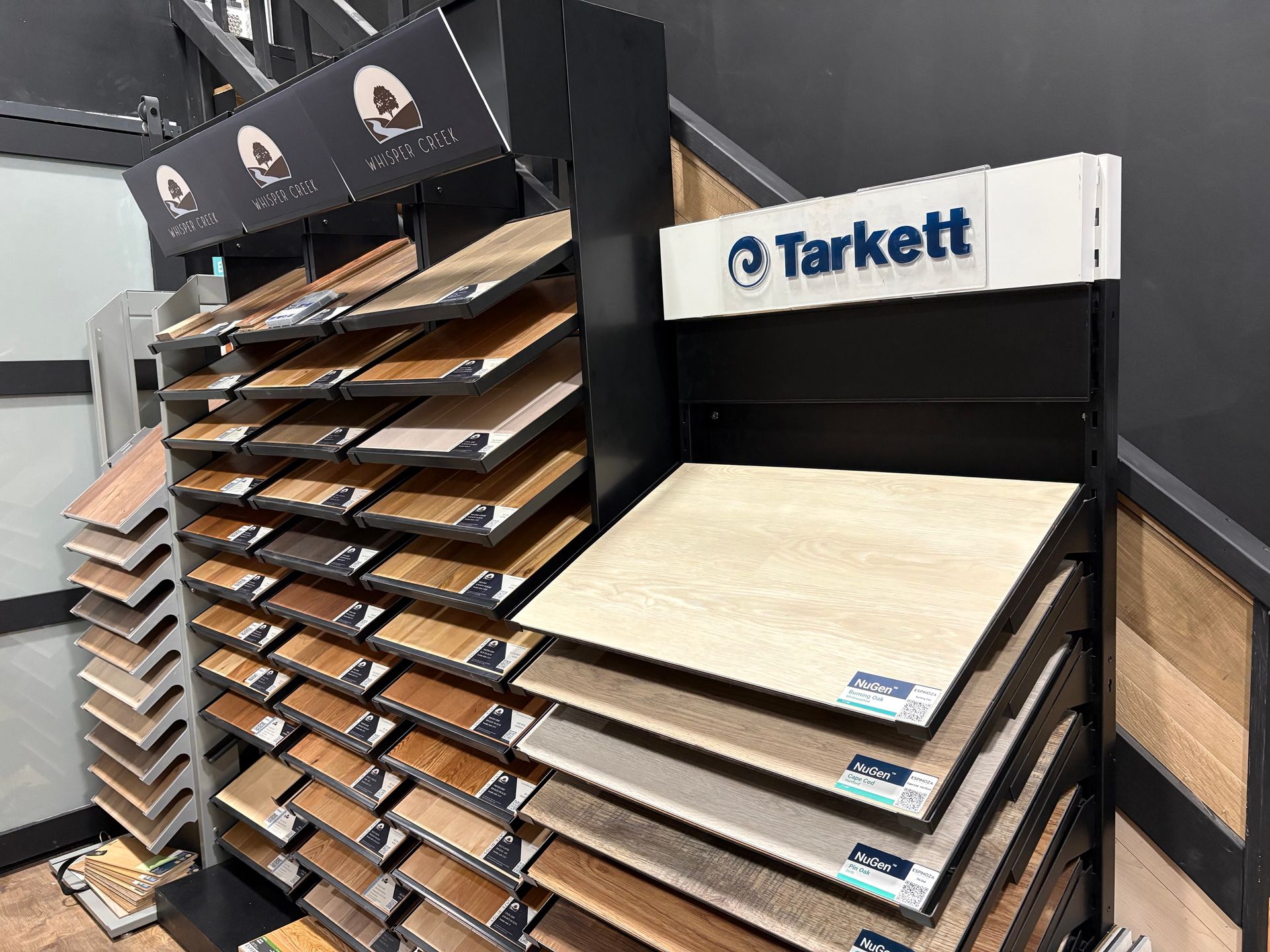 Newly refinished hardwood floor in a well-lit hallway with light filtering in from a doorway at the end.