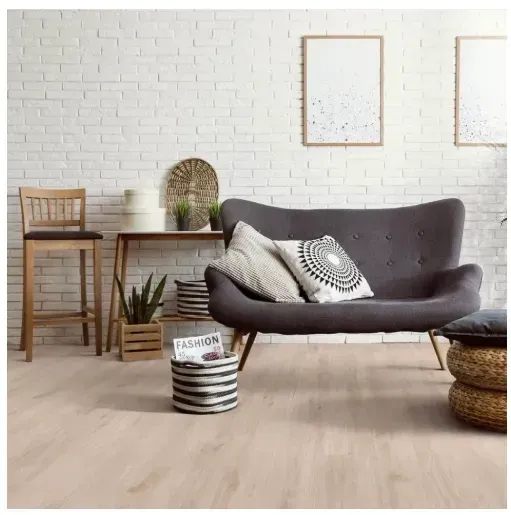 Living room with grey sofa, wooden table, and white brick wall.