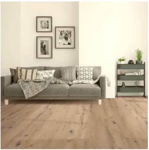 Living room with gray sofa, framed art, and wooden floors. A gray shelving unit is to the right.