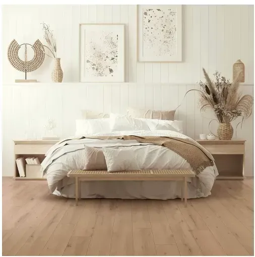 Bedroom with neutral color scheme, bed with woven bench, artwork, and decorative accents.