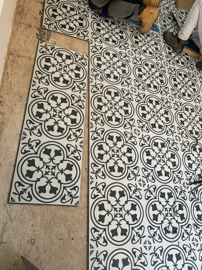 Installing patterned black and white floor tiles.
