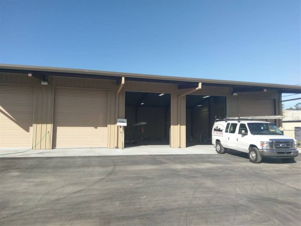 A white van is parked in front of a building.