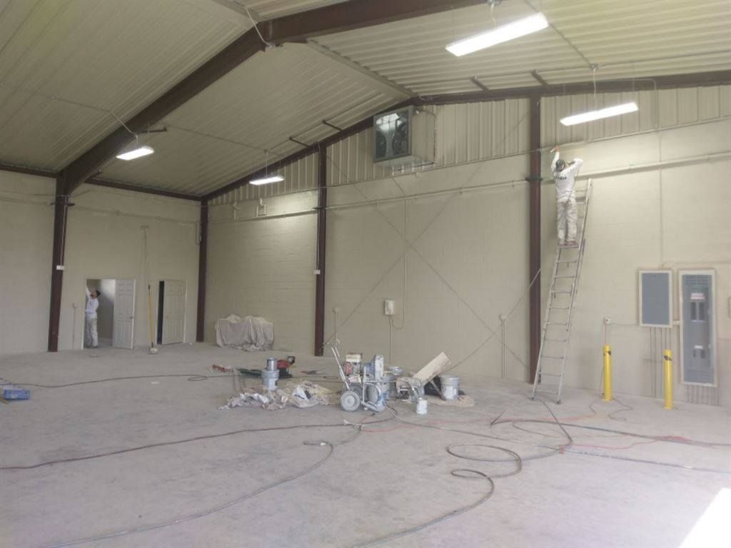 A man is painting the walls of a large building.