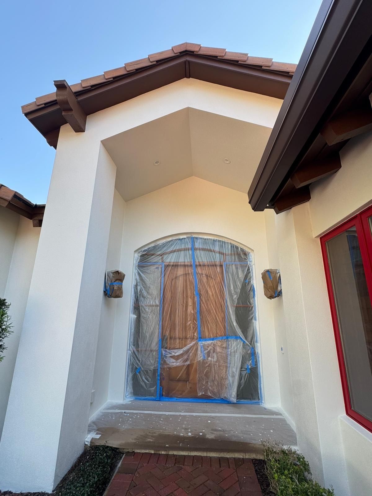 The front door of a house is covered in plastic.