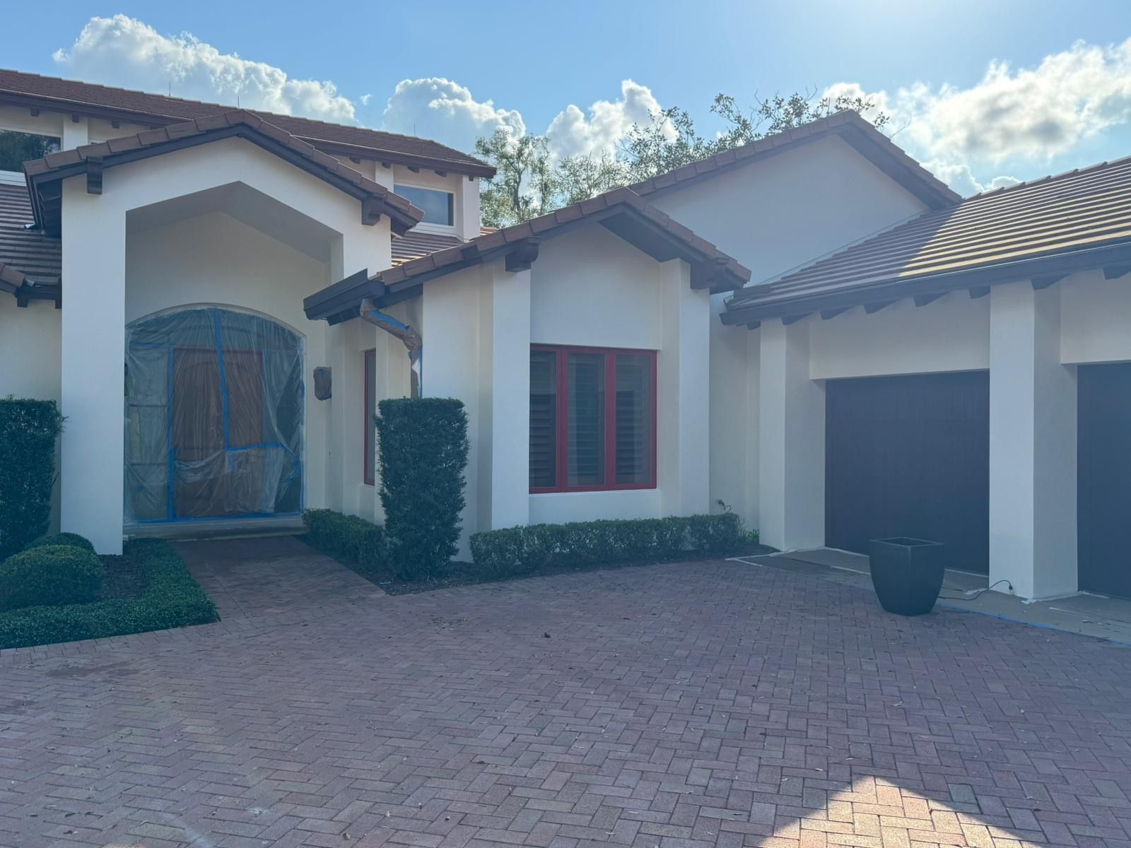 A large white house with a brick driveway in front of it