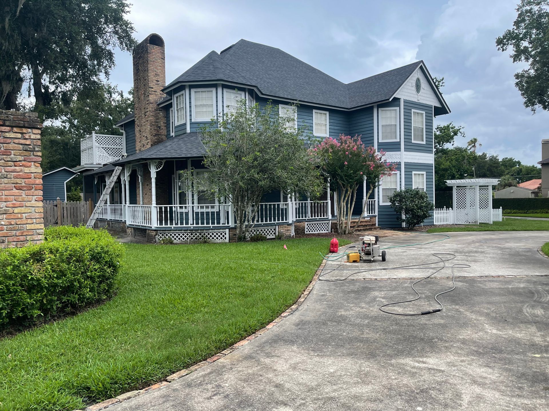 A large blue and white house with a fire hydrant in front of it.