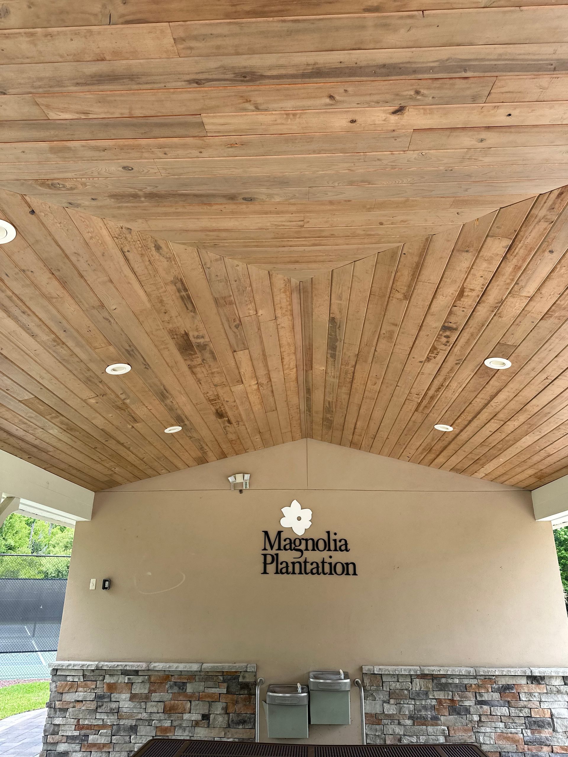 The ceiling of a building with wooden beams and a sign that says magnolia plantation.