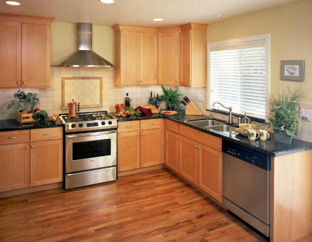 Kitchen with wooden cabinets, stainless steel appliances, and wood flooring.