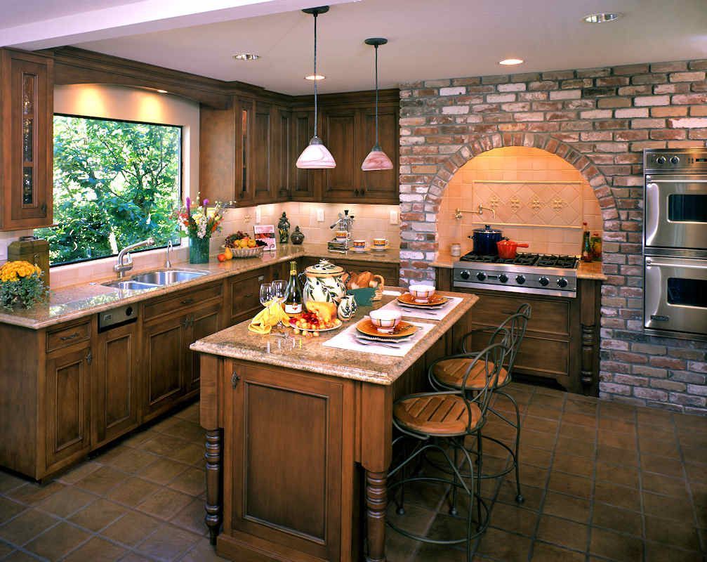 Kitchen with wood cabinets, brick accent wall, island with seating, and large window.