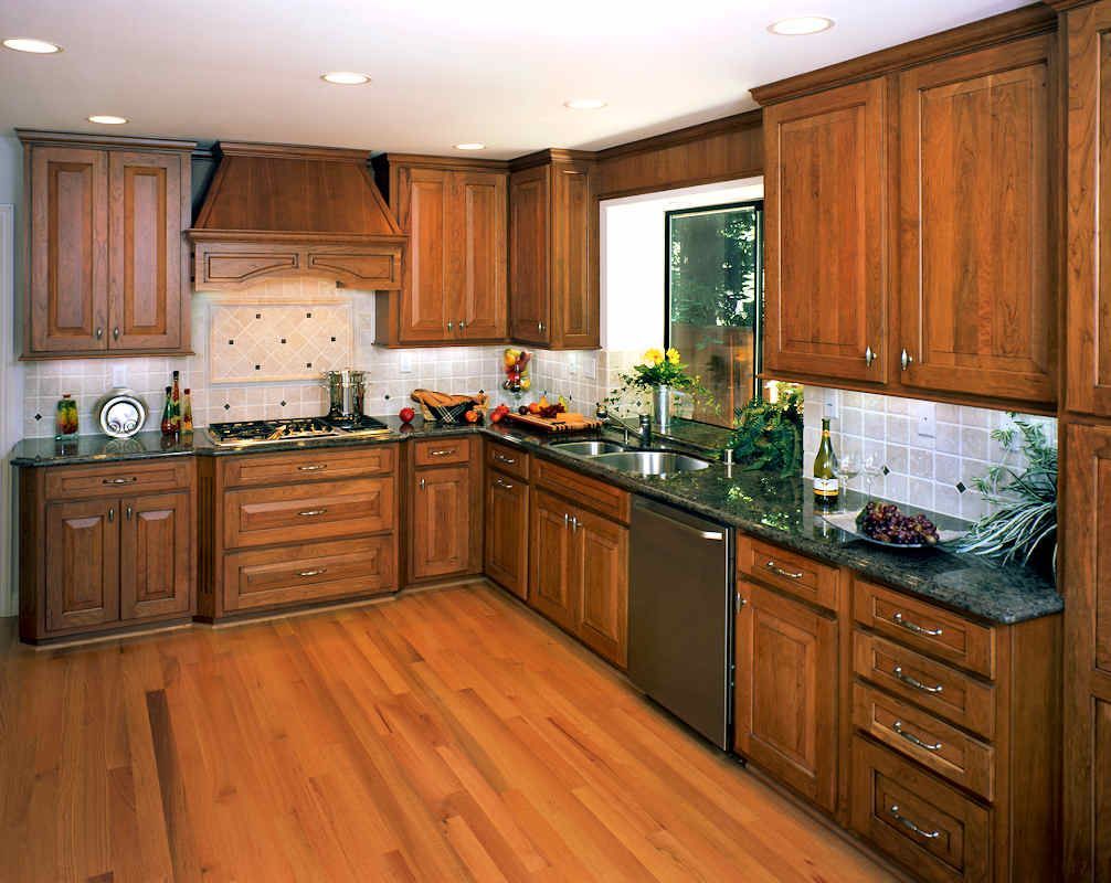 Kitchen with wooden cabinets, granite countertops, stainless steel appliances, and wood flooring.