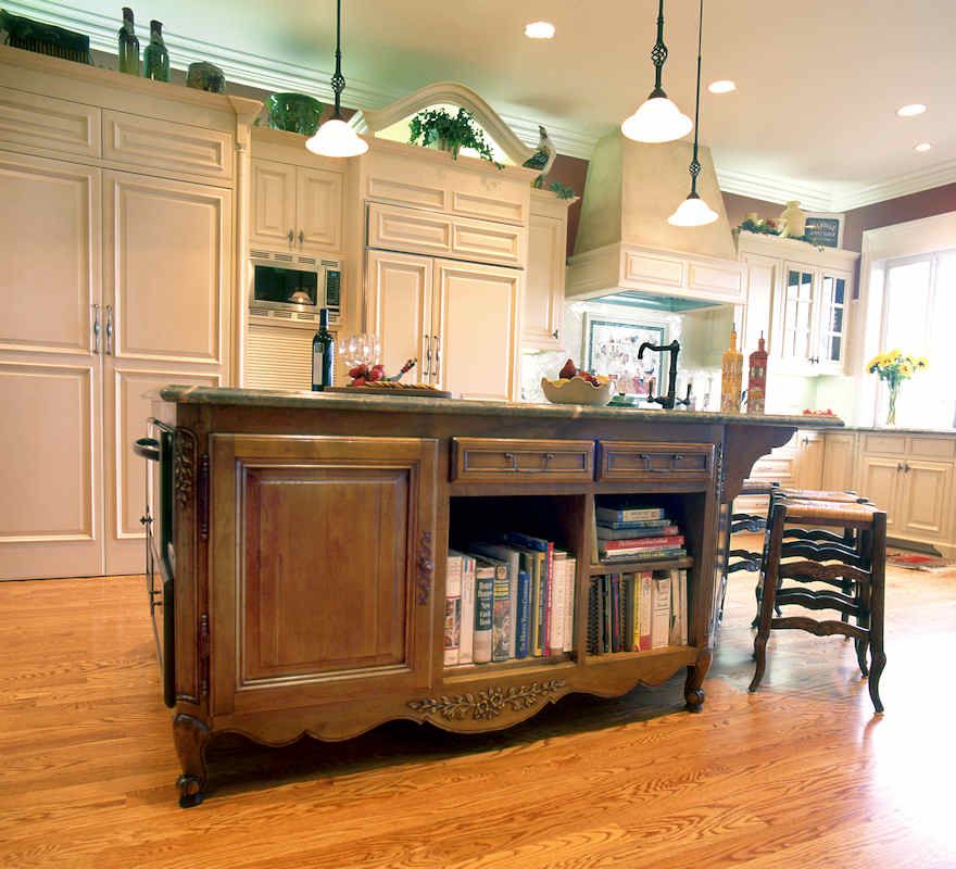Kitchen island with books, cabinets, and overhead pendant lights.