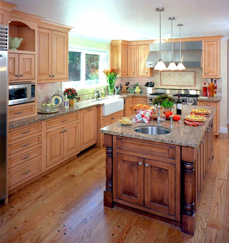 Spacious kitchen with wood cabinets, island with sink, and light granite countertops.