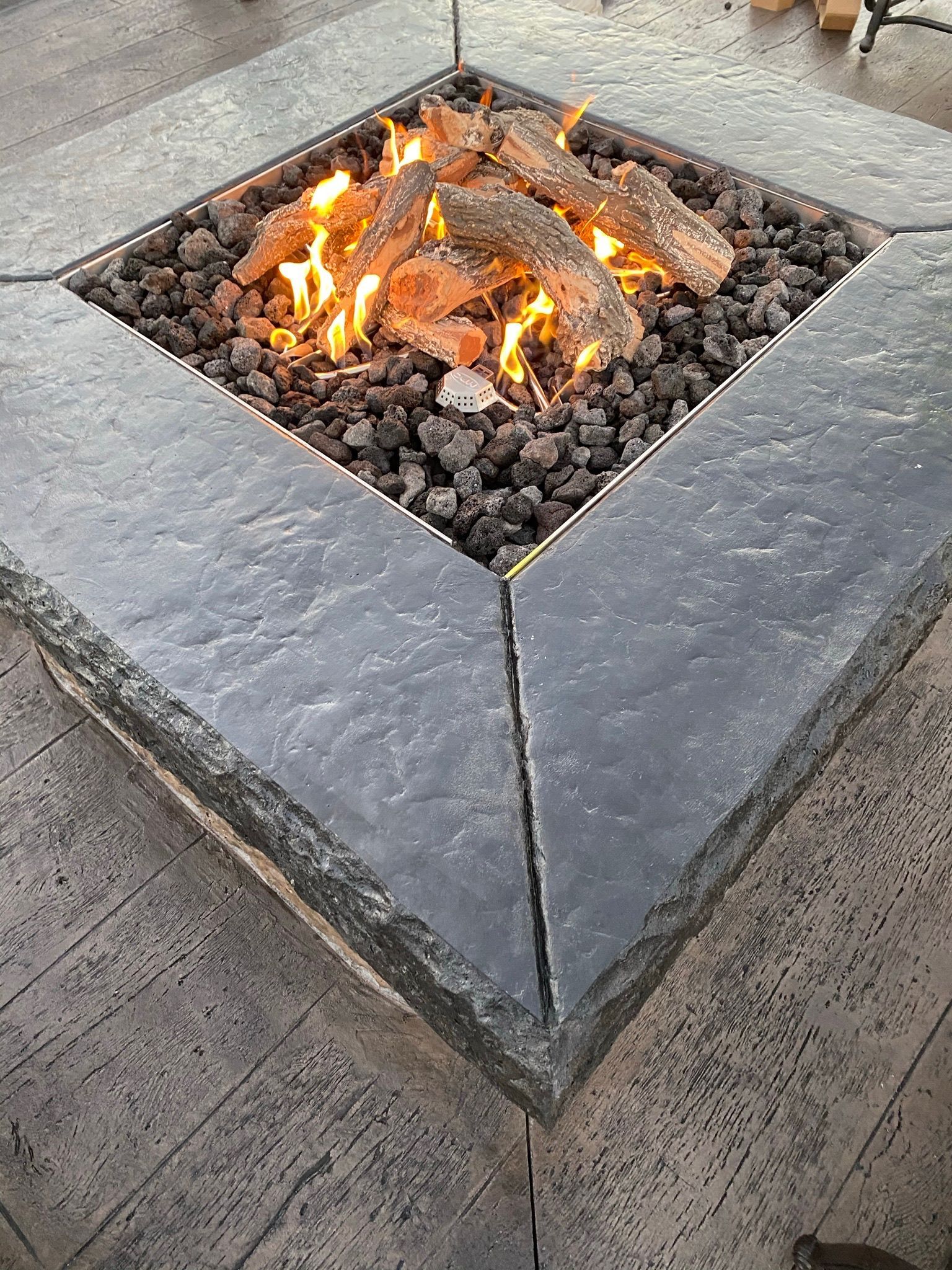 Burning fire pit with dark gray stone surround.