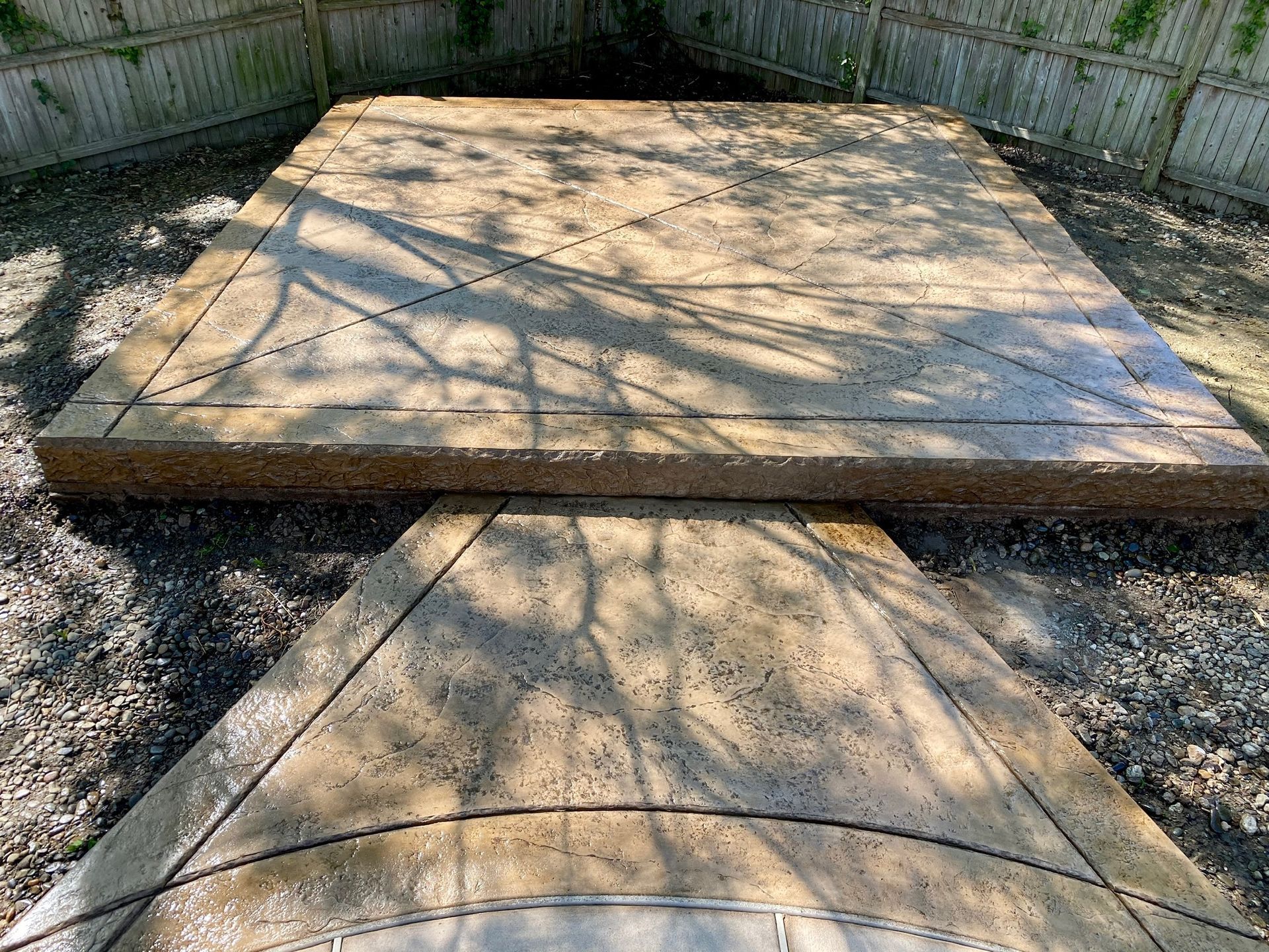 Two concrete slabs, one square and one triangular, outdoors with shadows.