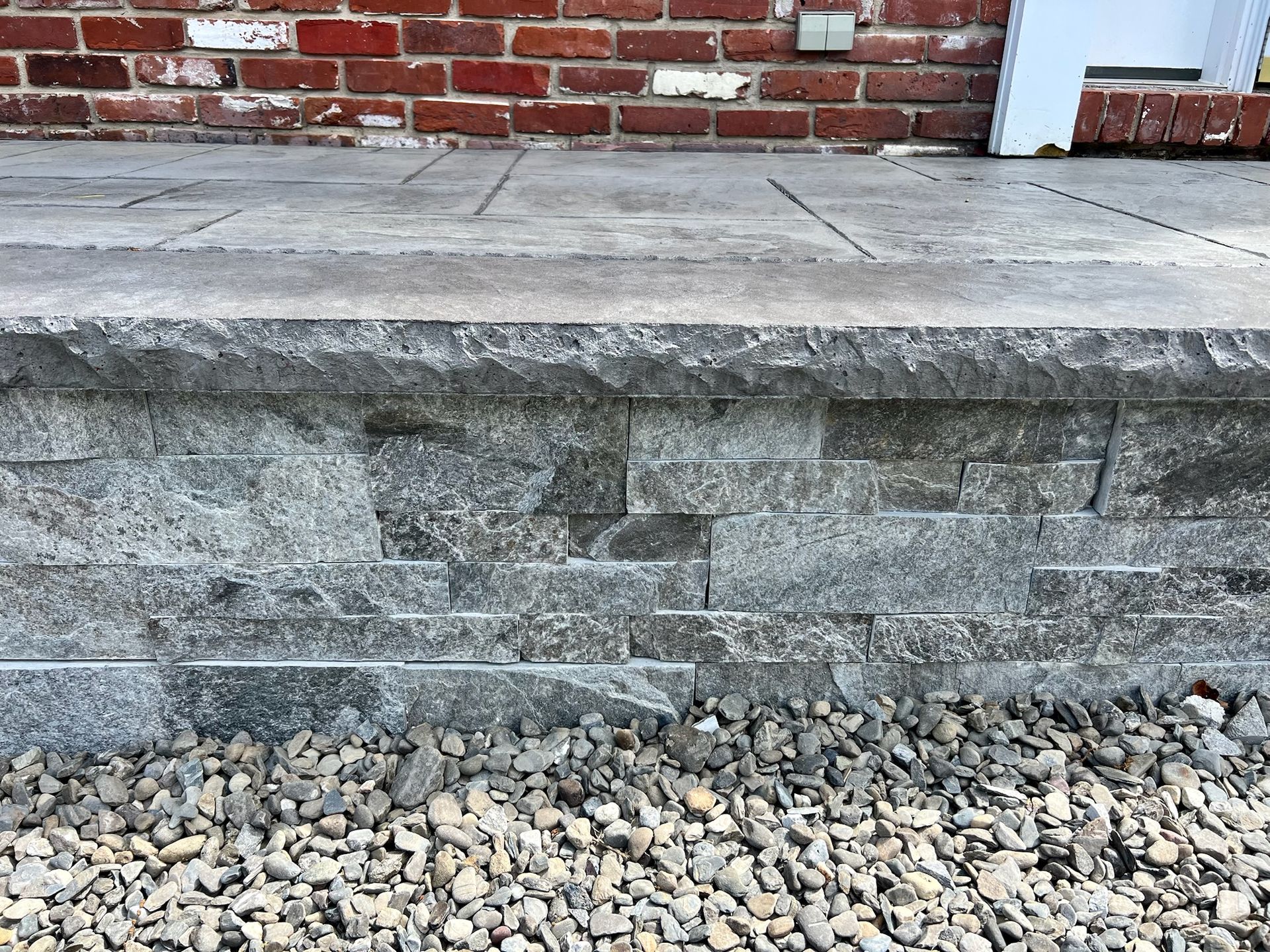 Stone steps with brick background and gravel base.