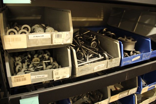 Shelves of labeled bins filled with assorted metal hardware bolts, screws, and washers