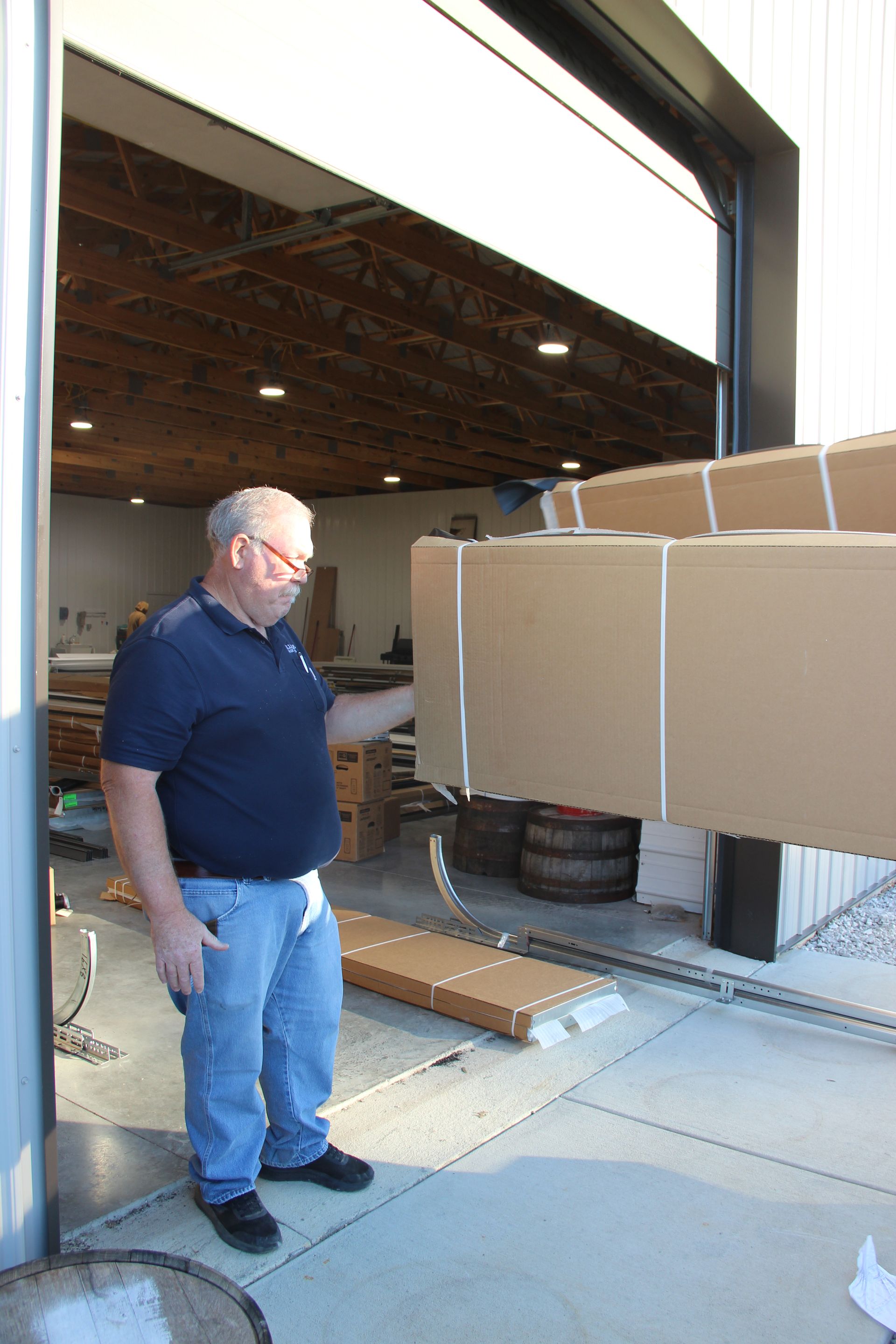 Man loading large cardboard boxes on a dolly at a warehouse doorway