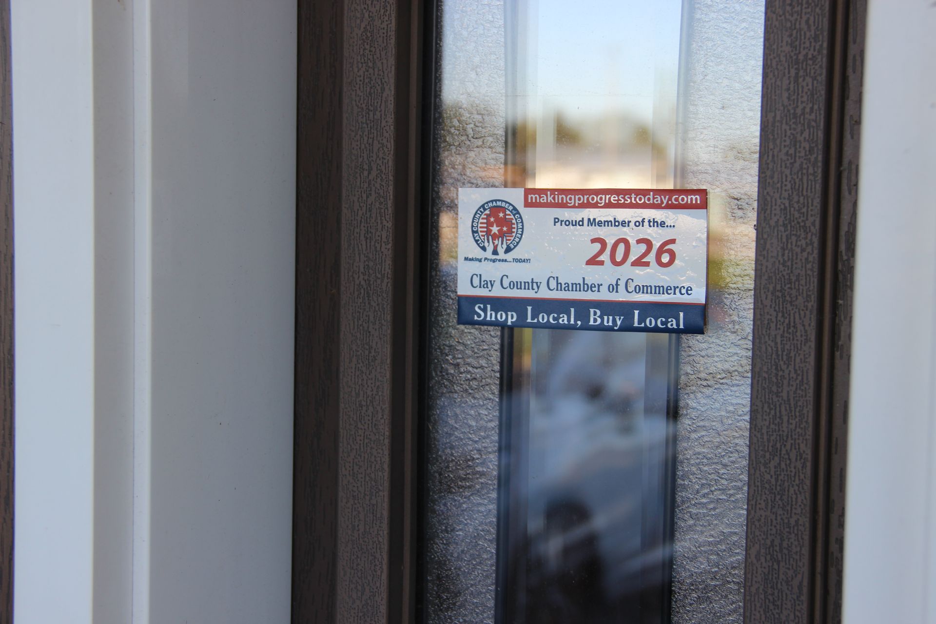Door with a “2026” election-style sign and “Stay Local, Buy Local” text