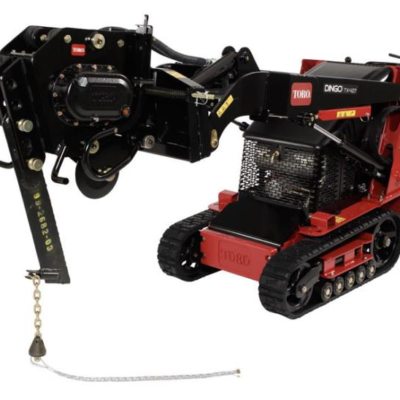 Red Toro Dingo compact utility loader with black trencher attachment.