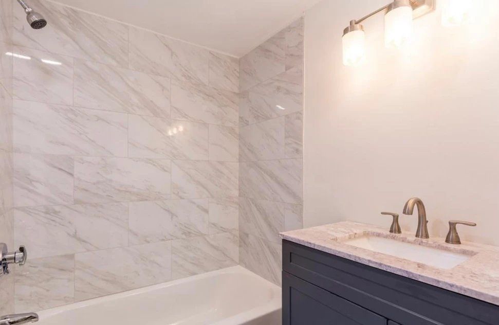 A bathroom with a bathtub, sink, and shower.