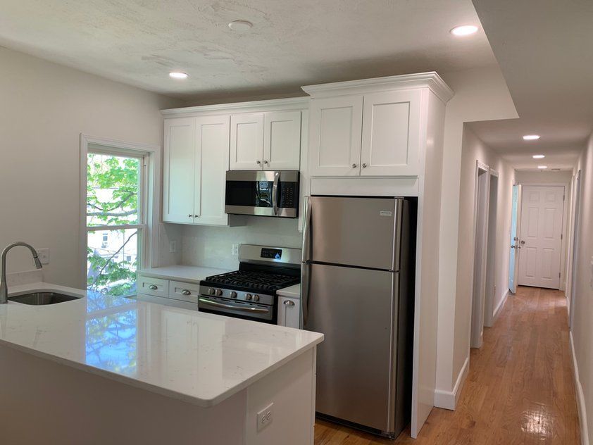 A kitchen with stainless steel appliances and white cabinets