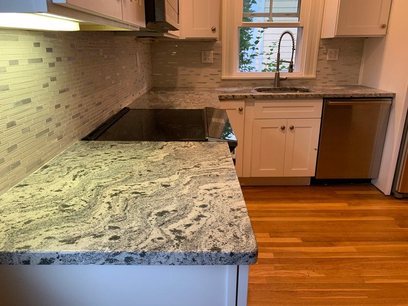 A kitchen with a stove top oven, sink, and dishwasher.