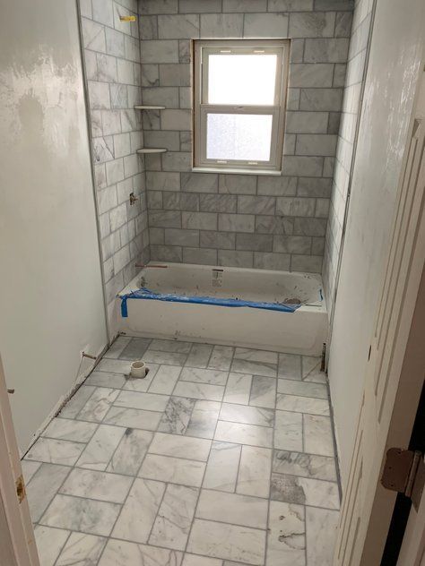 A bathroom with a bathtub and a window.