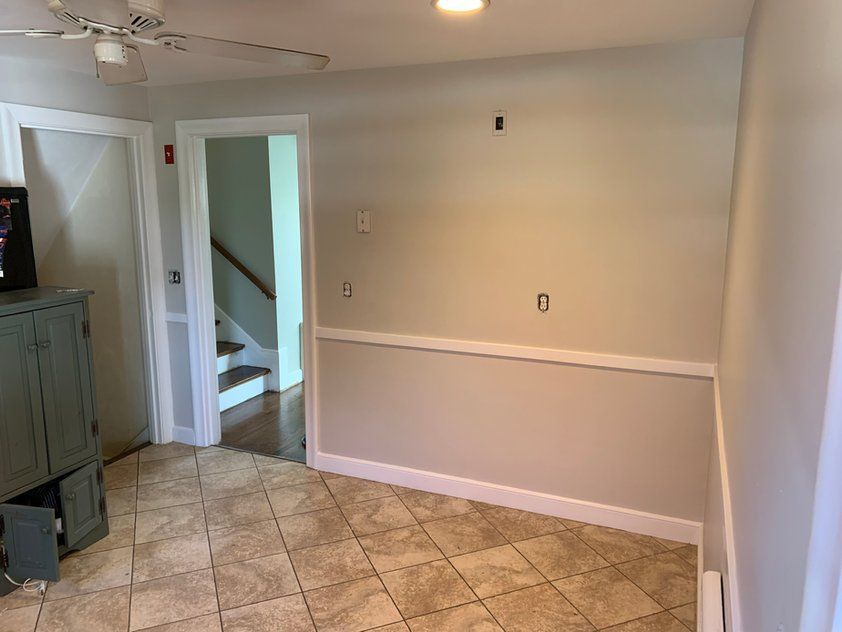 An empty room with a ceiling fan and stairs.