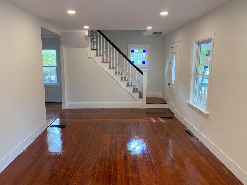 An empty living room with hardwood floors and stairs.