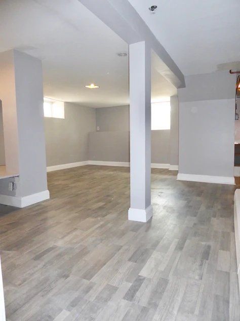 An empty room with a wooden floor and pillars
