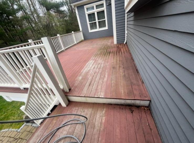 A wooden deck with a white railing and a hose attached to it.