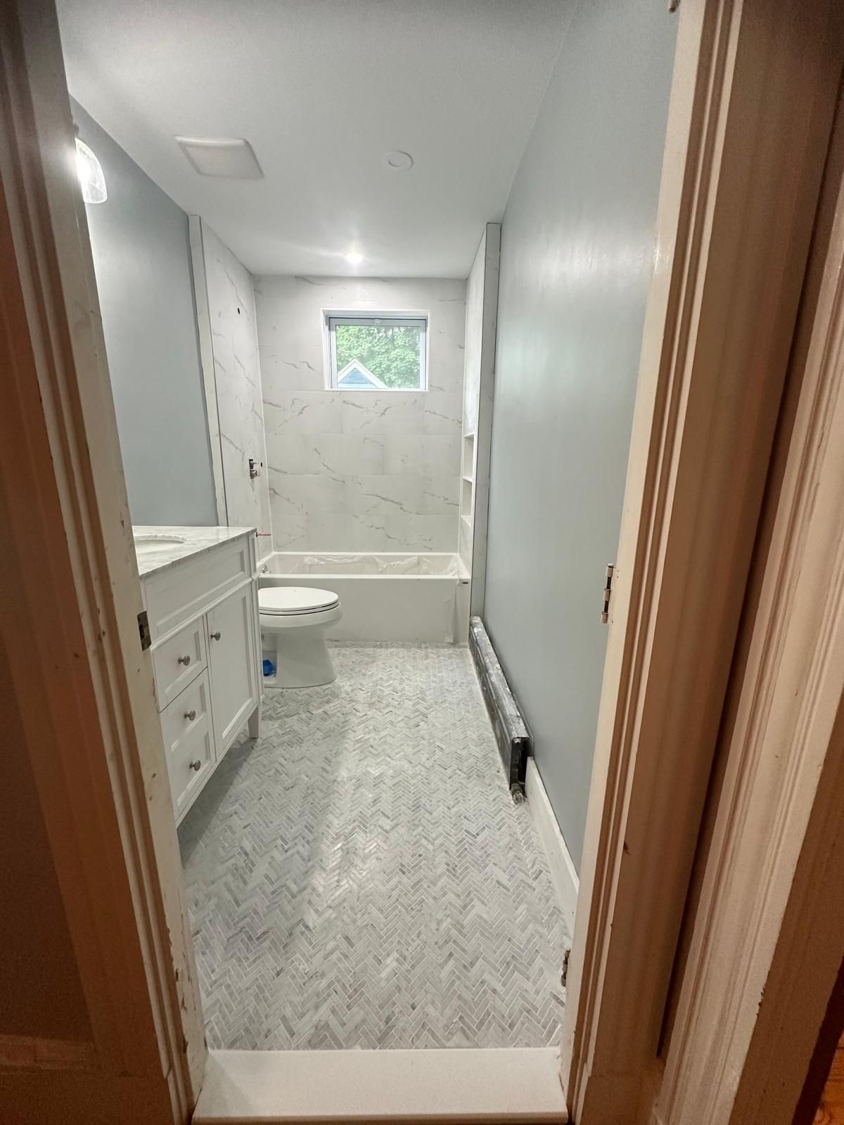 A bathroom with a toilet, sink, and bathtub.