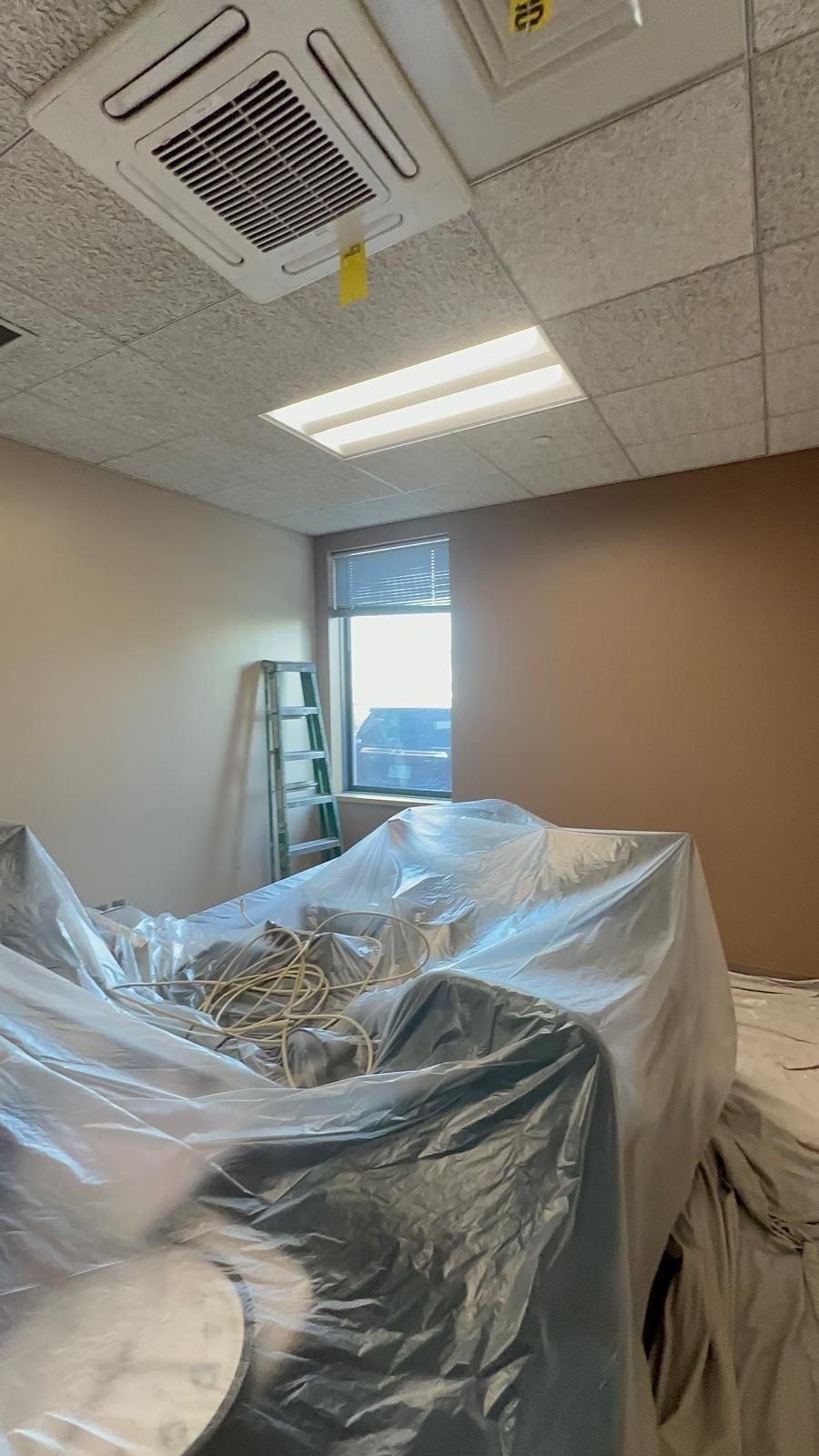 A room is being painted and covered in plastic.