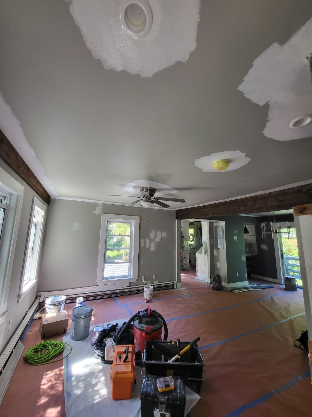 A living room with a ceiling fan and a table with tools on it.