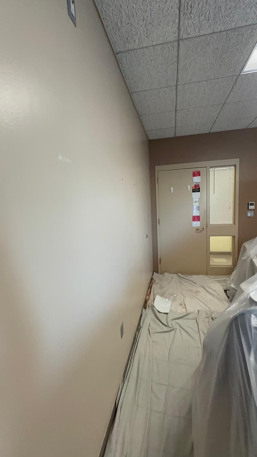A room with a door and a ceiling is being painted.