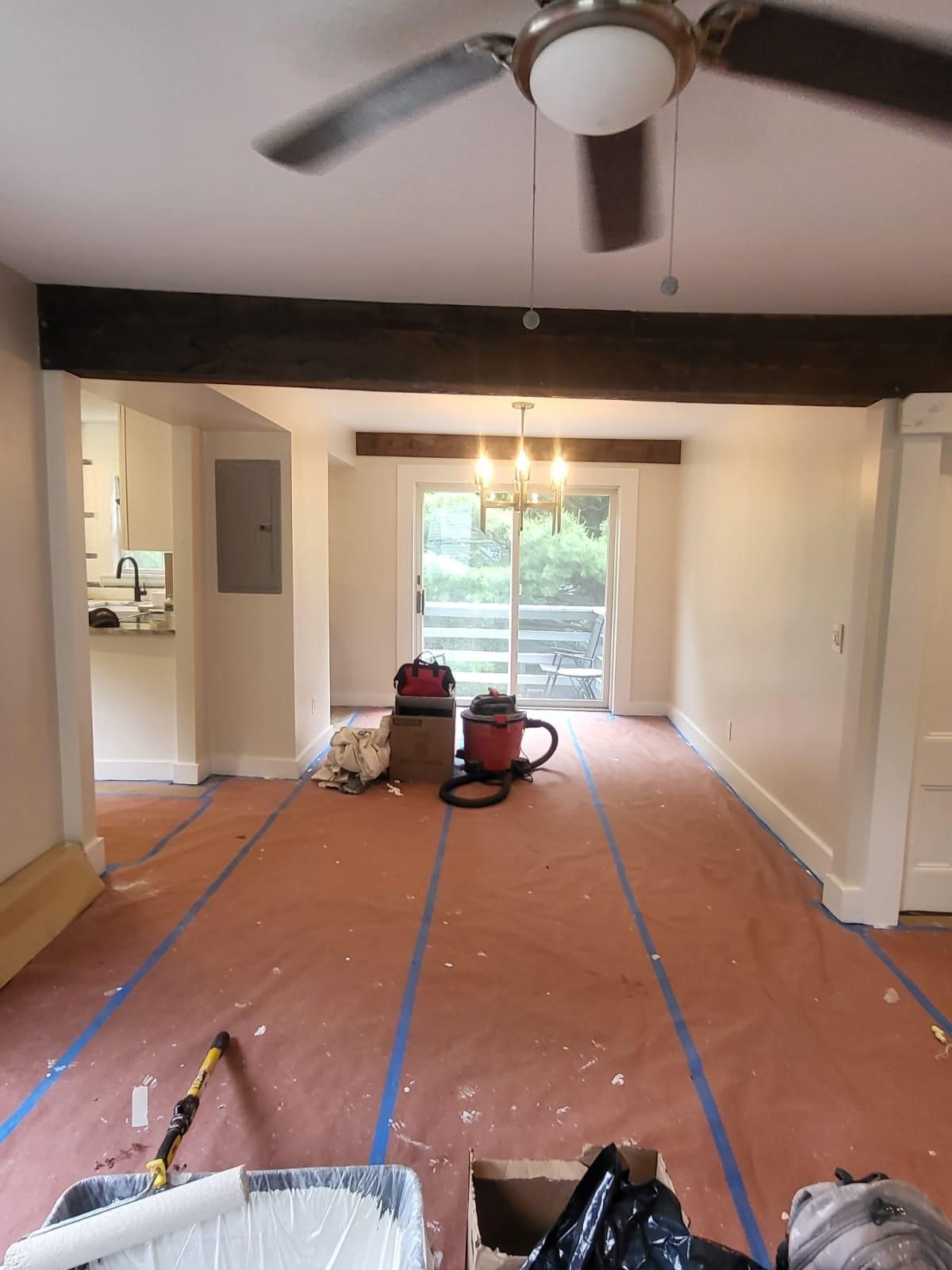 An empty room with a ceiling fan and a sliding glass door