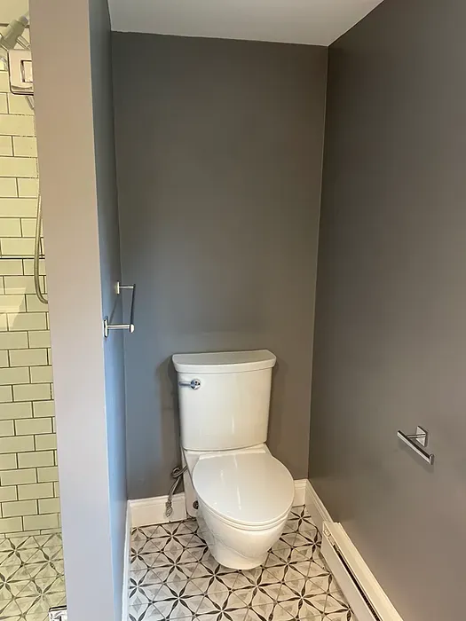 A toilet is sitting in a bathroom next to a shower.