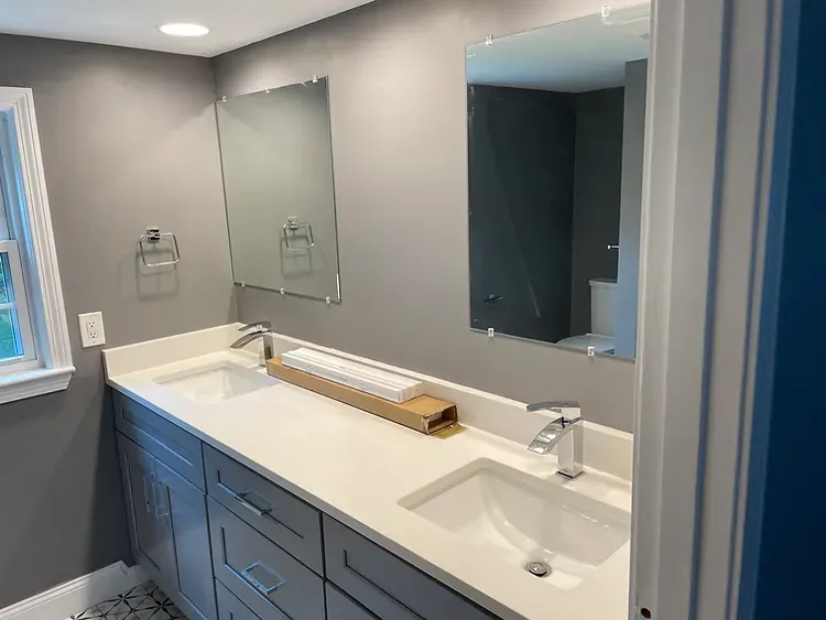 A bathroom with two sinks and two mirrors.