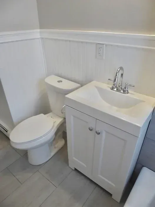 A bathroom with a toilet , sink and bathtub