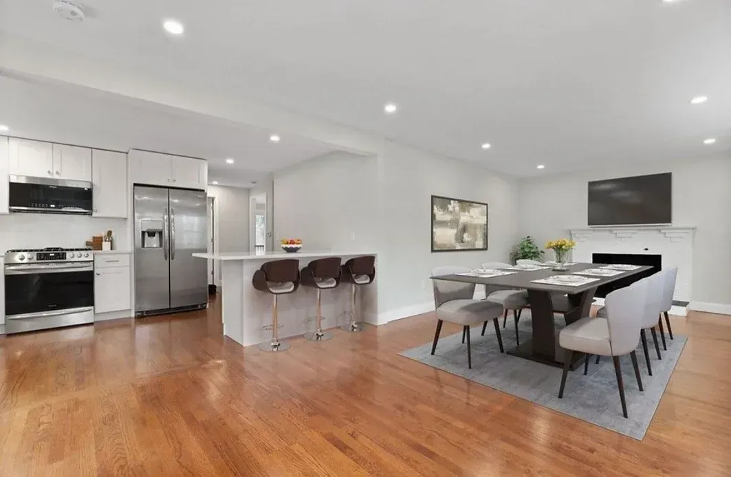 A kitchen and dining room in a house with hardwood floors.