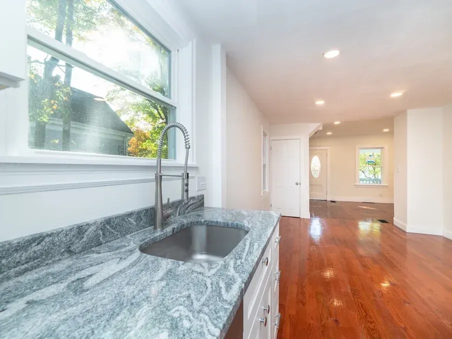 A kitchen with a granite counter top and a sink.