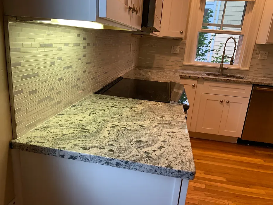 A kitchen with granite counter tops , a sink , and a stove.